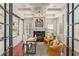 Well-lit home office featuring built-in shelving, a fireplace, and hardwood floors at 506 Golfpark Dr, Celebration, FL 34747