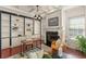 Bright home office with a cozy fireplace, custom built-ins, and hardwood flooring at 506 Golfpark Dr, Celebration, FL 34747
