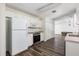 Clean kitchen featuring white cabinets and appliances, laminate flooring, and functional layout at 520 Via Verona Ln # 202, Altamonte Springs, FL 32714