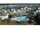 Beautiful aerial view of community pool, clubhouse, and surrounding homes and ponds at 542 Pine Tree Bridge Trl, St Cloud, FL 34772