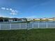 Backyard featuring a white picket fence, grassy yard and scenic pond view at 542 Pine Tree Bridge Trl, St Cloud, FL 34772