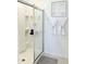 Sleek shower with clear glass door, modern fixtures, and white shelving for storage at 542 Pine Tree Bridge Trl, St Cloud, FL 34772