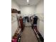 Organized walk-in closet features shelving, hanging racks, and ample space for storage, including shoes and accessories at 542 Pine Tree Bridge Trl, St Cloud, FL 34772