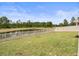 Spacious, grassy backyard with a white picket fence overlooking a pond at 5457 Carrara Ct, St Cloud, FL 34771