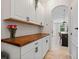 Butler's pantry features white cabinets, wood countertop, and an archway to the dining area at 5457 Carrara Ct, St Cloud, FL 34771