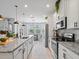Bright kitchen featuring granite countertops, stainless steel appliances, and adjacent dining area at 5457 Carrara Ct, St Cloud, FL 34771