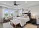 Serene main bedroom showcases tray ceiling, lots of windows and decor for a relaxing retreat at 5457 Carrara Ct, St Cloud, FL 34771