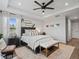 Bright main bedroom offers a relaxing retreat with tray ceiling, windows, decor, and a cozy seating area at 5457 Carrara Ct, St Cloud, FL 34771