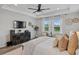 Bright main bedroom shows a tray ceiling, large windows, dresser, bed, and wood-look flooring at 5457 Carrara Ct, St Cloud, FL 34771
