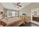 Bright bedroom featuring a ceiling fan, three pane window, and dresser with television at 6201 Goethe St # 103, Orlando, FL 32835