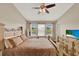 Bright bedroom featuring a ceiling fan, three pane window, and dresser with television at 6201 Goethe St # 103, Orlando, FL 32835
