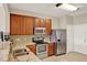 Kitchen featuring stainless steel appliances, wooden cabinets, and granite countertops at 6201 Goethe St # 103, Orlando, FL 32835