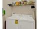 Laundry room featuring a white washer and dryer and a shelf of cleaning supplies at 6201 Goethe St # 103, Orlando, FL 32835