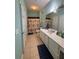 A bathroom with double sinks, white cabinets, large mirror, and tile flooring at 6335 Contessa Dr # 310, Orlando, FL 32829