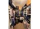 A walk-in closet featuring custom shelving filled with clothes, shoes, and storage containers at 6335 Contessa Dr # 310, Orlando, FL 32829