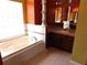 Elegant bathroom with a large soaking tub and vanity at 7045 Branch Ct, St Cloud, FL 34771