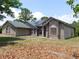 Side view of a one-story home featuring stucco walls, a green roof, solar panels and a red trim at 7045 Branch Ct, St Cloud, FL 34771
