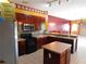 Well-lit kitchen featuring wood cabinets, stainless steel appliances, tile backsplash, and adjacent living areas at 7045 Branch Ct, St Cloud, FL 34771