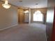Carpeted living room with chandelier, bright window, and views into adjacent rooms at 7045 Branch Ct, St Cloud, FL 34771