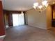 Carpeted living room with chandelier, showing views through a bright window and access to adjacent rooms at 7045 Branch Ct, St Cloud, FL 34771