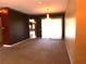 Carpeted living room with chandelier and a bright window, showcasing views into adjacent rooms at 7045 Branch Ct, St Cloud, FL 34771