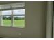Bedroom with window view overlooking green grass golf course with trees on a sunny day at 725 Ocean Course Ave, Davenport, FL 33896