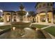 Exterior shot of the clubhouse at night with a tiered fountain in the foreground and warmly lit archways at 725 Ocean Course Ave, Davenport, FL 33896