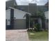 Modern townhome featuring a two-car garage, stone accents, and a well-manicured front lawn at 725 Ocean Course Ave, Davenport, FL 33896