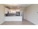 Open-concept kitchen with modern appliances, gray backsplash, breakfast bar, and tile flooring at 725 Ocean Course Ave, Davenport, FL 33896