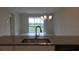 Spacious living room area adjacent to kitchen with outdoor views and sliding glass door at 725 Ocean Course Ave, Davenport, FL 33896
