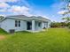 Expansive backyard with a covered patio, lush green lawn, and a light blue single-Gathering home at 8018 Colby Cir, Orlando, FL 32817