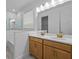Bright bathroom featuring a double vanity with modern sinks and a glass-enclosed shower/tub at 8018 Colby Cir, Orlando, FL 32817