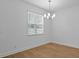 Dining room featuring modern chandelier, window, and light wood-look flooring at 8018 Colby Cir, Orlando, FL 32817