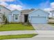 Charming one-story home with a blue facade, well-manicured lawn, and stylish stone accents at 8018 Colby Cir, Orlando, FL 32817