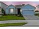 Charming one-story home with a blue facade, well-manicured lawn, and stylish stone accents at 8018 Colby Cir, Orlando, FL 32817