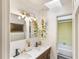 Bright bathroom with double sink vanity, decorative plants, and shower visible through open doorway at 803 Arlington Blvd, Altamonte Springs, FL 32701