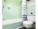 Retro-style bathroom featuring light green tile, white fixtures, and new vinyl flooring at 803 Arlington Blvd, Altamonte Springs, FL 32701