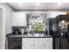 Bright kitchen with stainless steel sink, black appliances, and a window over looking greenery at 803 Arlington Blvd, Altamonte Springs, FL 32701