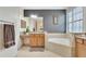Bathroom features a soaking tub with granite counters, tile floor and decorative wall at 8439 Prestbury Dr, Orlando, FL 32832