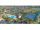 Aerial view of community featuring multiple pools, a playground, tennis courts, a lake, parking, and green spaces at 8439 Prestbury Dr, Orlando, FL 32832