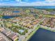 Aerial view of a community that features many houses, lakes, ponds, green spaces, a golf course, and a community pool at 8439 Prestbury Dr, Orlando, FL 32832