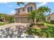 Beautiful two-story home with a paver driveway, two-car garage and lush, tropical landscaping at 8439 Prestbury Dr, Orlando, FL 32832