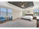 Bright main bedroom features an elevated ceiling, ceiling fan and large windows for natural light at 8439 Prestbury Dr, Orlando, FL 32832