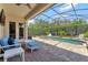 Screened in pool with brick patio, seating, and well maintained landscaping at 8439 Prestbury Dr, Orlando, FL 32832