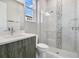 Modern bathroom featuring a glass shower door, white vanity, and stylish grey cabinets at 891 Megano Blvd, Deland, FL 32724