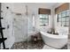 Bathroom with a large glass shower and a soaking tub by the window at 9104 Stromboli Ct, Kissimmee, FL 34747