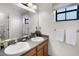 Bright bathroom featuring double sinks, updated fixtures, and a large mirror at 9104 Stromboli Ct, Kissimmee, FL 34747