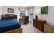 Comfortable bedroom featuring a wooden bed frame with bookcase headboard and adjacent work desk area at 9104 Stromboli Ct, Kissimmee, FL 34747