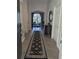 Inviting foyer with a dark rug and a glimpse into the living room, showcasing a seamless transition and warm atmosphere at 9104 Stromboli Ct, Kissimmee, FL 34747