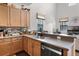 Modern kitchen featuring light wood cabinets, stainless steel appliances, and a breakfast bar at 9104 Stromboli Ct, Kissimmee, FL 34747